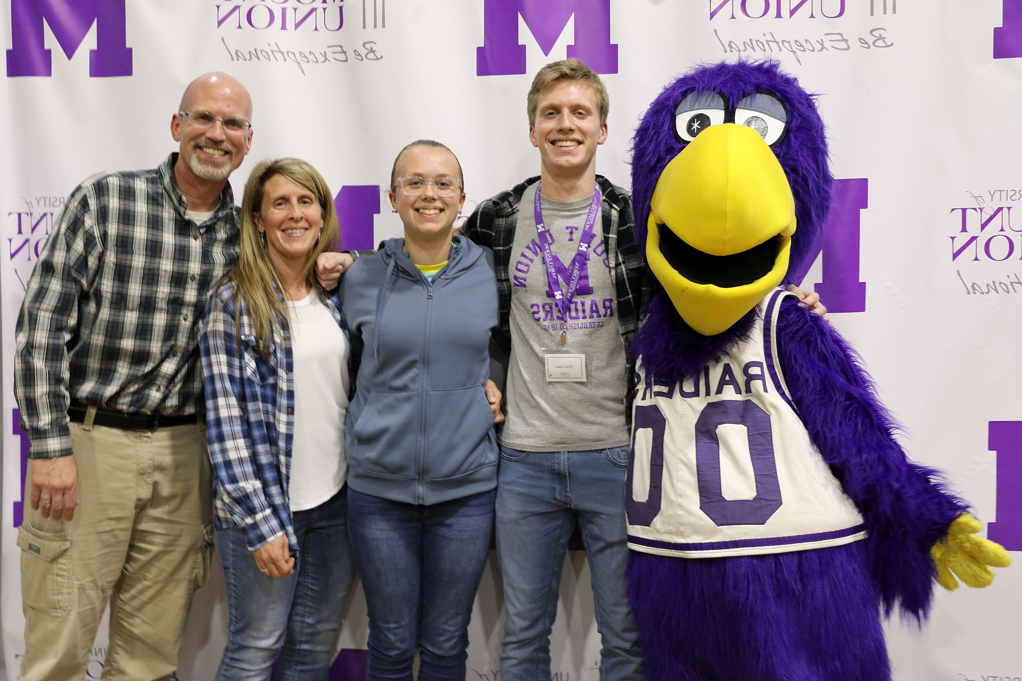 Purple Raider family posing with Mount Union mascot, MUcaw.