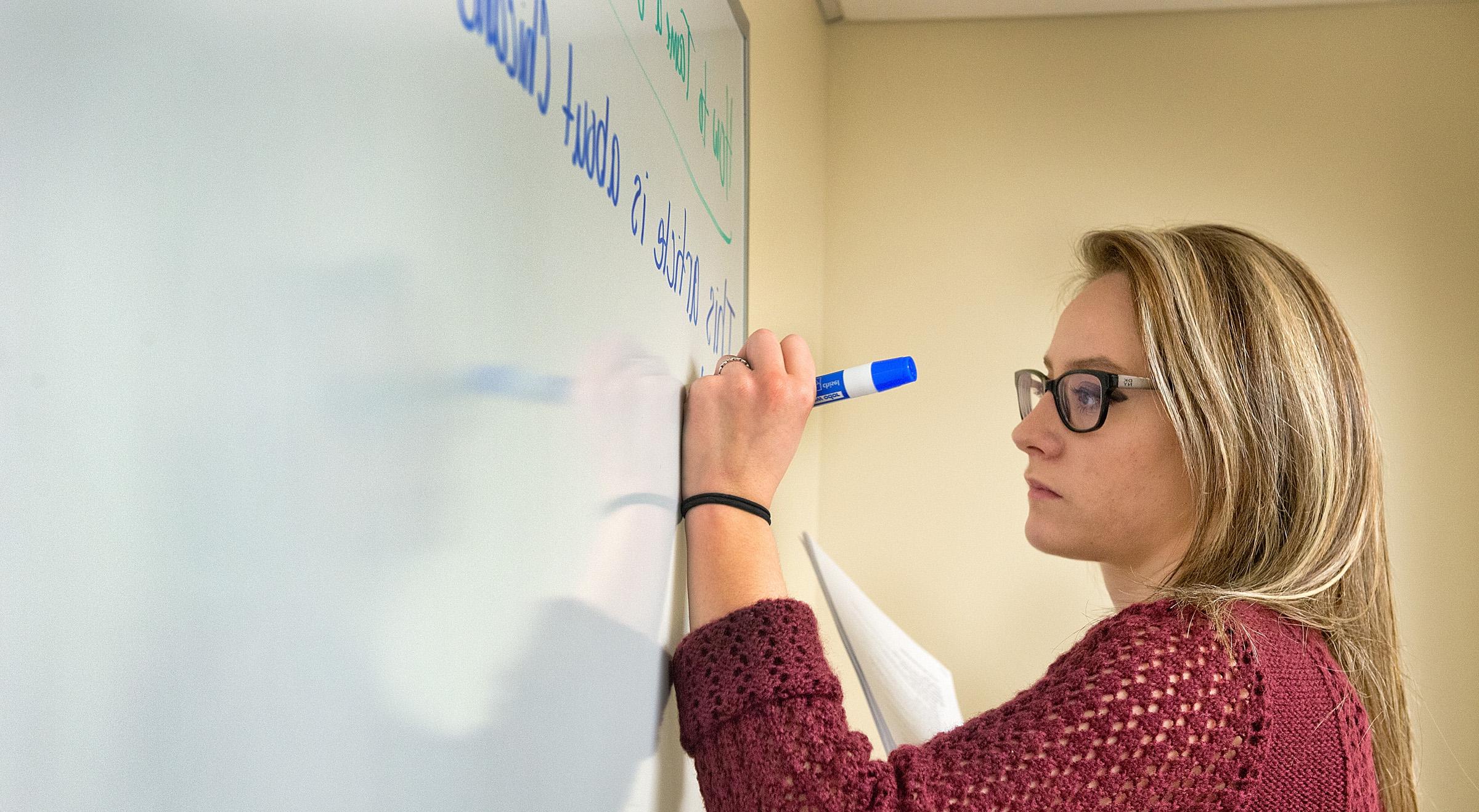 University of Mount Union student writing on a whiteboard 